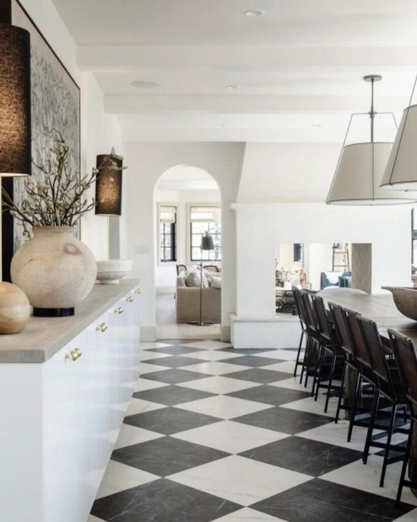 Black and white checkered diamond floor in a bright modern kitchen and dining area.