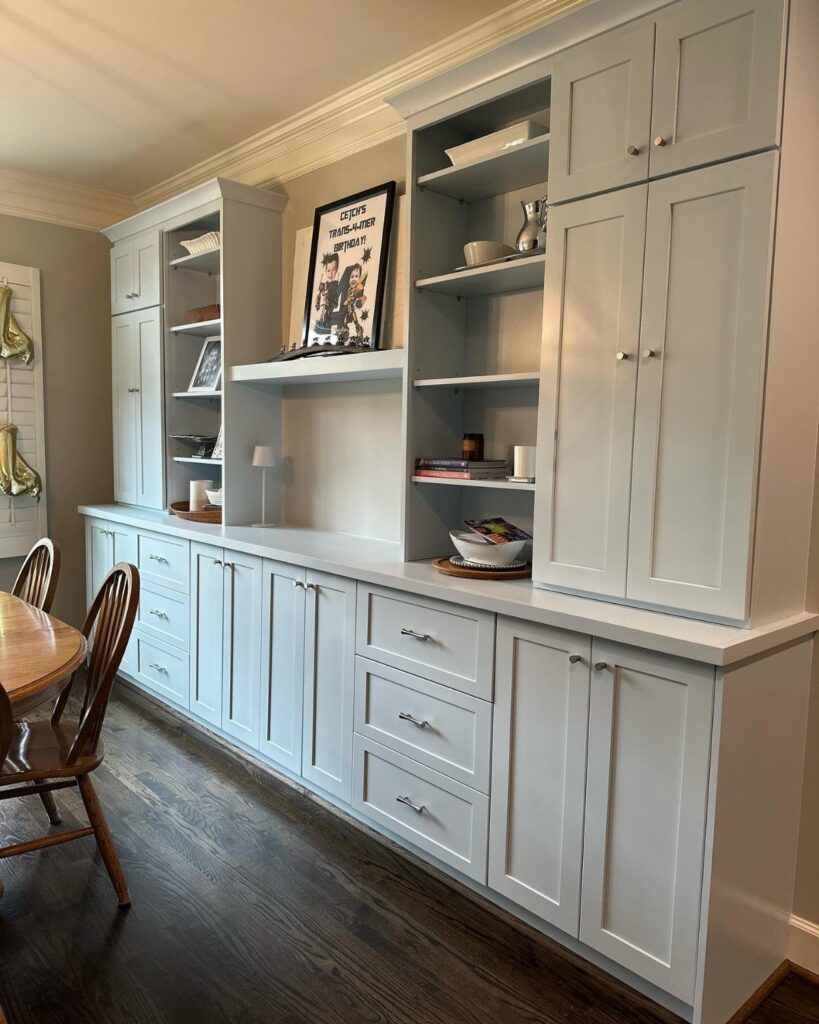 White built-in dining room cabinets with a long sideboard and upper open shelving.