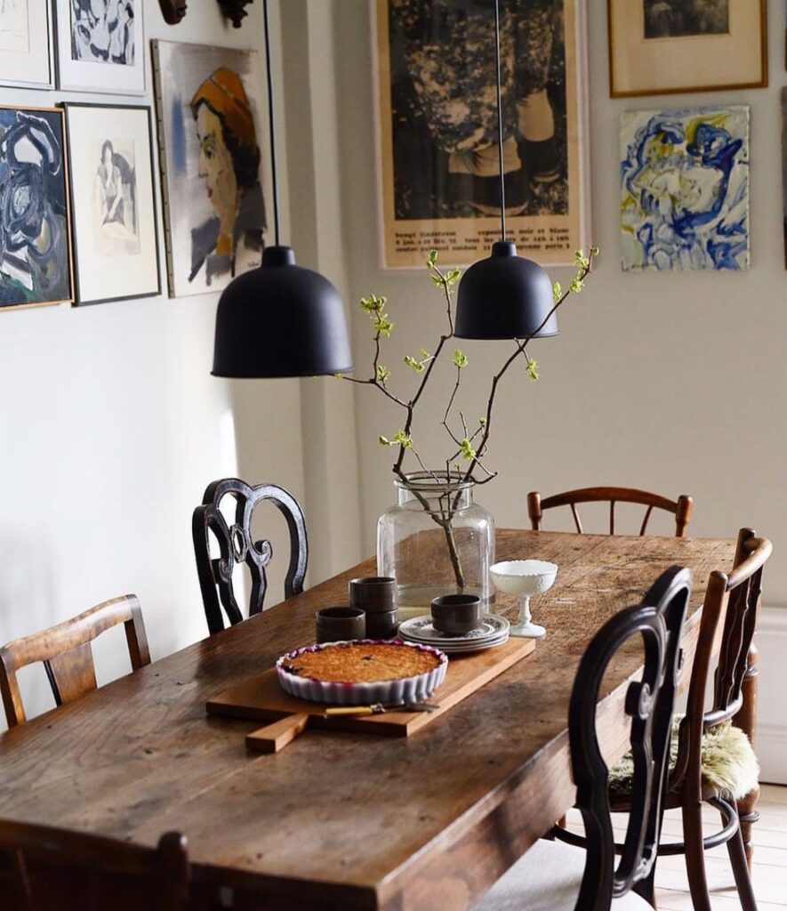 Rustic wooden dining table surrounded by mismatched black and brown wooden chairs.
