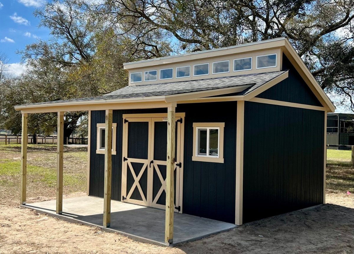 Black wooden shed with a covered porch and cream trim in a yard.